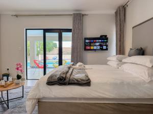 a bedroom with a bed and a table and a patio at Berrybliss Guesthouse - Sandton in Sandton