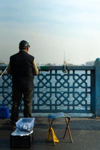a man standing next to a fence with a fish at Vidanta in Nuevo Nayarit
