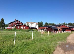 a fence in a field with houses in the background at Helsingebockens Fastigheter in Bollnäs
