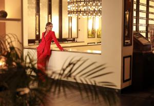 a woman in a red suit standing behind a counter at Villa Blanca Urban Hotel in Casablanca