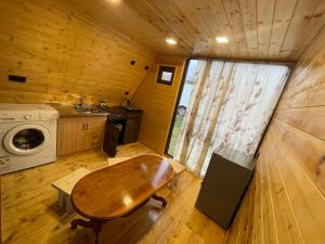 Sunset Cottage Busheti : مطبخ صغير مع طاولة خشبية ومغسلة