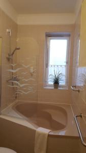 a bathroom with a bath tub and a window at Idylle am See in Zossen +24 photos