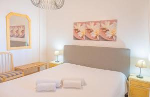 una camera da letto con un letto bianco con due asciugamani sopra di Torre da Rocha 601A a Praia da Rocha