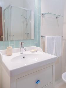 un bagno con un lavandino bianco e uno specchio di Torre da Rocha 601A a Praia da Rocha Altre 27 foto
