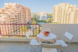 un tavolo e sedie su un balcone con edifici di Torre da Rocha 601A a Praia da Rocha