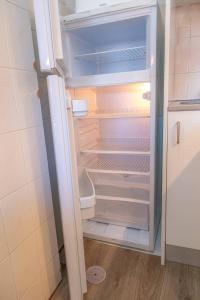 un frigorifero vuoto con la porta aperta in una cucina di Torre da Rocha 601A a Praia da Rocha