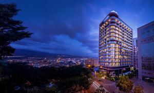 a tall building with lights on it at night at The Smallville Hotel in Beirut