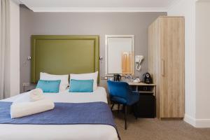 a hotel room with a large bed and a desk at The Porchester Hotel in London +121 photos