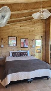 una camera da letto con un letto grande in una parete di legno di Cabañas Potrero de Marquez Paraiso Adult only a Potrero de Garay