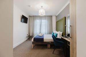 a hotel room with a bed and a desk at The Porchester Hotel in London