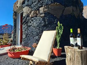 a chair and two bottles of wine next to a wall at Funco Du Santos in Portela