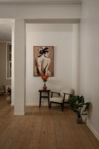 ein Wohnzimmer mit einem Stuhl und einem Gemälde an der Wand in der Unterkunft Nordic Luxury Suite near Downtown in Tromsø