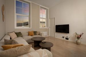 ein Wohnzimmer mit Sofa und Fernseher in der Unterkunft Nordic Luxury Suite near Downtown in Tromsø