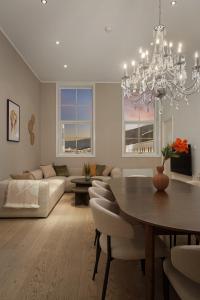 ein Wohnzimmer mit einem Esstisch und einem Kronleuchter in der Unterkunft Nordic Luxury Suite near Downtown in Tromsø