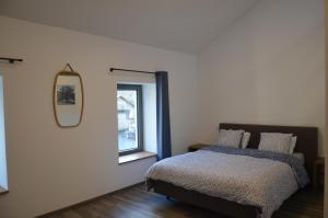 a bedroom with a bed and a mirror on the wall at Au pied de La Redoute in Sougné-Remouchamps