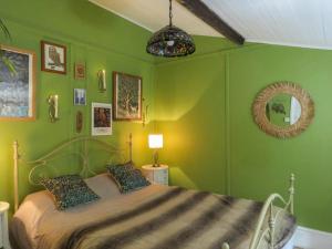 a green bedroom with a bed and a mirror at Bluebell Cottage At Lurley Manor in Washfield