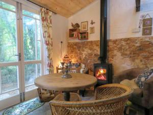 a living room with a table and a fireplace at Bluebell Cottage At Lurley Manor in Washfield
