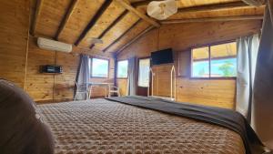 a bedroom with a bed in a room with wooden walls at Cabañas Potrero de Marquez Paraiso Adult only in Potrero de Garay