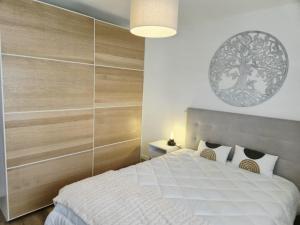 ein Schlafzimmer mit einem weißen Bett und einer Holzwand in der Unterkunft Downtown apartment - Terrace, garage and pool in Olhão