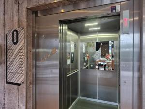 a metal elevator in a building with a glass door at B&B HOTEL Massy Gare TGV in Massy