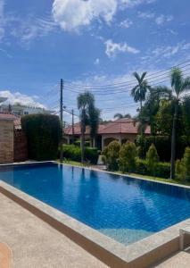 ein großer blauer Swimmingpool vor einem Haus in der Unterkunft Sea sand Bungalow in Phuket + 2 Fotos