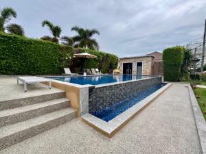 a swimming pool with a bench next to a house at Sea sand Bungalow in Phuket