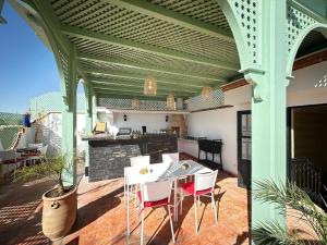 a patio with a table and chairs on a roof at Riad Jadis in Marrakesh
