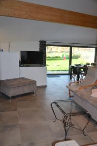 a living room with a couch and a tv at Au pied de La Redoute in Sougné-Remouchamps