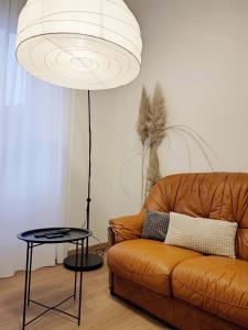 VECCHIA FERROVIA Orvieto Apartment في أورفييتو سكالو: غرفة معيشة مع أريكة بنية ومصباح +6 صور