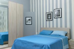 una camera con un letto blu e tre immagini sul muro di Giualduomo B&B a SantʼAgata deʼ Goti