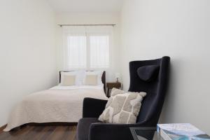 a bedroom with a bed and a chair and a window at Pool & Cozy Apartment Warszawa Bukowińska by Solarento in Warsaw