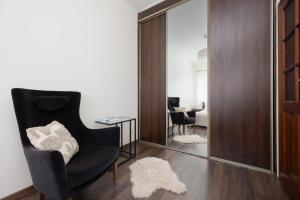 a living room with a chair and a mirror at Pool & Cozy Apartment Warszawa Bukowińska by Solarento in Warsaw