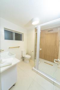 Un baño con inodoro y ducha de cristal. en Sand and Sea 25, en Swakopmund