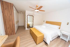 Un dormitorio con una cama blanca y un espejo. en Sand and Sea 25, en Swakopmund