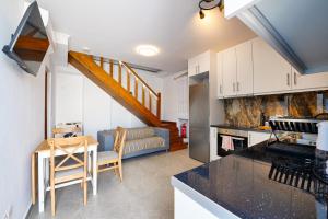 a kitchen and living room with a couch and a table at Stylish villa Antika close to the shops and restaurants in Korissia, Kea in Korissia