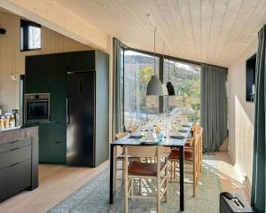 a dining room with a table in a kitchen at Stylish Mountain Cabin In Hallingdalen in Flå +33 photos