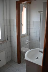 a bathroom with a toilet and a sink and a window at The Domus in Olmedo