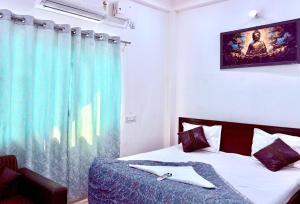 1 dormitorio con 1 cama con cortina azul en Majestic Inn Home Stay, en Varanasi