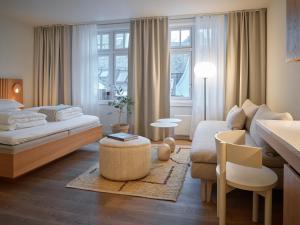 a bedroom with a bed and a living room at Hotel 1904 in Ålesund