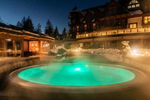 a hot tub in the middle of a courtyard at night at Tatra Resort & SPA in Kościelisko