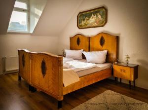 a bedroom with a wooden bed with a painting on the wall at Villa Dietel Greiz in Greiz