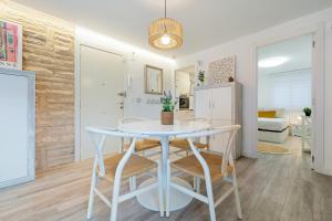 a dining room with a table and chairs and a refrigerator at Hauzify I Apartament Kempenland in Salou
