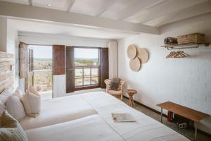 a bedroom with a large white bed and a window at Gonana Guesthouse in Paternoster +95 photos