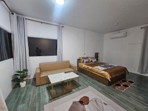 a living room with a bed and a couch at Kanyapa Resort กัณญภา แก่งกระจาน in Kaeng Krachan