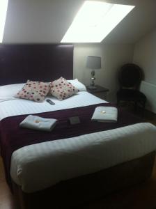 een slaapkamer met een groot bed met twee handdoeken erop bij Abbey Lodge B&B in Galway