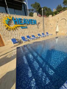 a swimming pool with chairs and a sign on a wall at Sunheaven resort in Al Qarşā