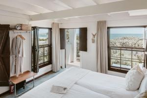 a bedroom with a bed and a large window at Gonana Guesthouse in Paternoster +95 photos