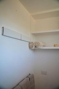 Una cocina con paredes blancas y un estante con toallas. en Harbour Lane Stay, en Geraldton