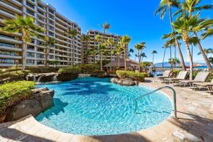 a large swimming pool with palm trees and a building at Kaanapali Alii 385 · ALII 385 Corner 2BD OceanFront Dream Vacati in Kaanapali