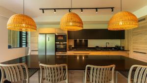a kitchen with a black table with chairs and chandeliers at Modern and comfortable apartment in Pointe aux Cannoniers